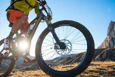 Close up of aluminum bike frame and wheels as man rides in mountainous area